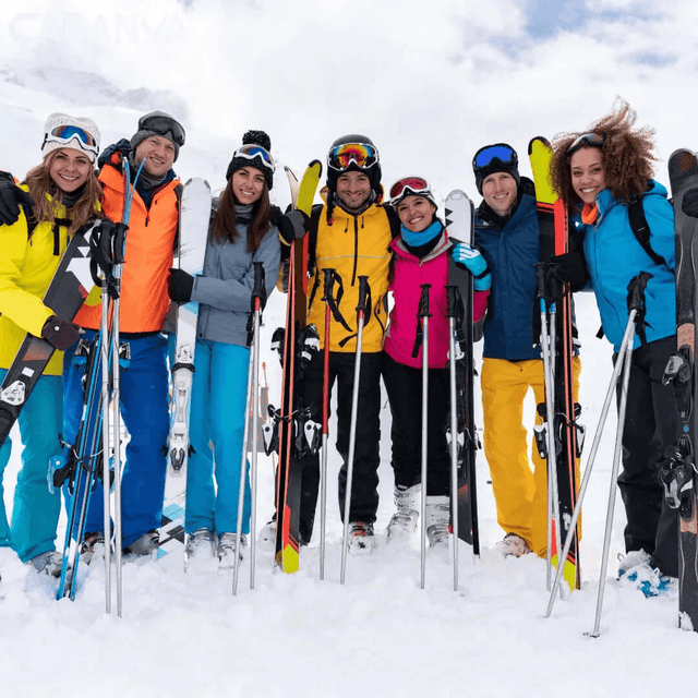 Grupo de amigos sonriendo en la nieve con sus esquís y bastones